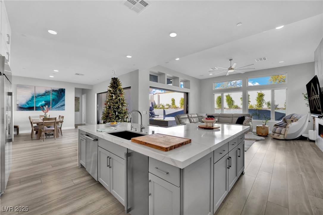 397 Highview Rdg Avenue Las Vegas, NV 89138 - Photo 95 of 97 Kitchen featuring open floor plan, light stone counters, ceiling fan, light wood-style floors, and recessed lighting