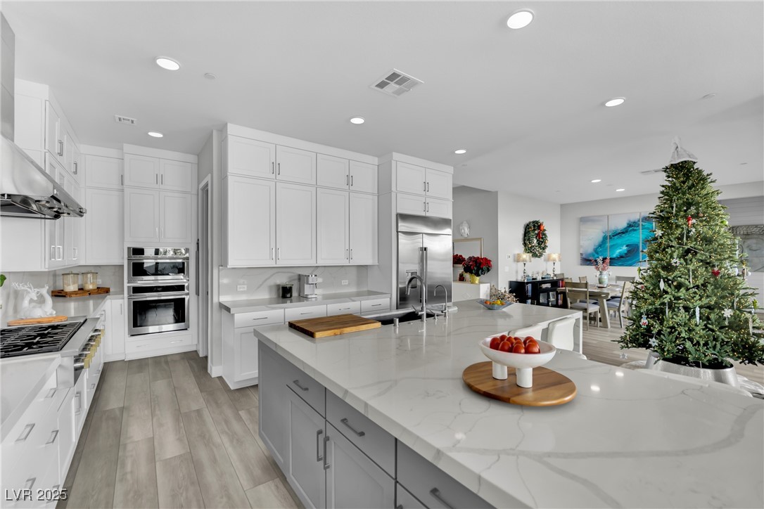 397 Highview Rdg Avenue Las Vegas, NV 89138 - Photo 38 of 97 Kitchen with light stone counters, wall chimney exhaust hood, gray cabinets, white cabinetry, and recessed lighting