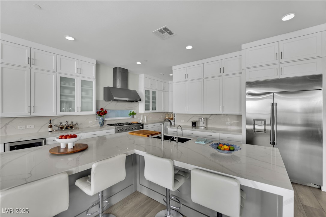 397 Highview Rdg Avenue Las Vegas, NV 89138 - Photo 39 of 97 Kitchen featuring appliances with stainless steel finishes, white cabinets, backsplash, light stone counters, and recessed lighting