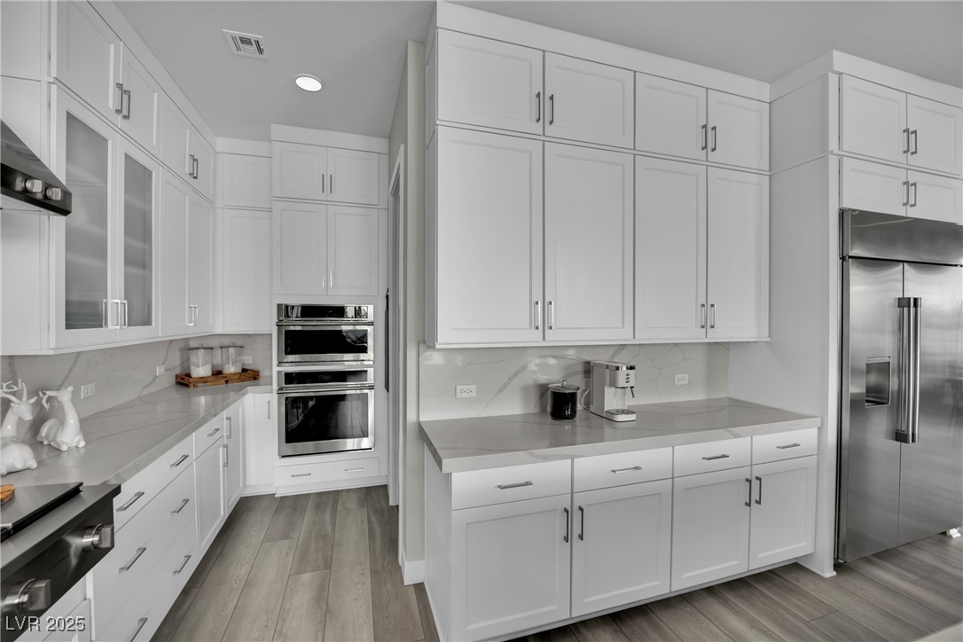 397 Highview Rdg Avenue Las Vegas, NV 89138 - Photo 44 of 97 Kitchen with stainless steel appliances, white cabinetry, tasteful backsplash, glass insert cabinets, and recessed lighting