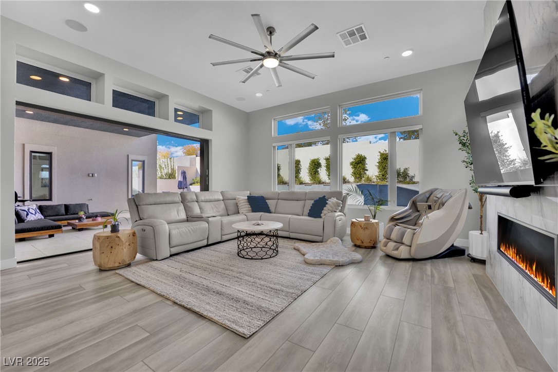397 Highview Rdg Avenue Las Vegas, NV 89138 - Photo 46 of 97 Living area featuring wood finished floors, a ceiling fan, a tiled fireplace, and recessed lighting