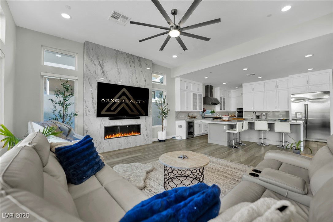 397 Highview Rdg Avenue Las Vegas, NV 89138 - Photo 50 of 97 Living room featuring ceiling fan, light wood-style floors, a premium fireplace, beverage cooler, and recessed lighting