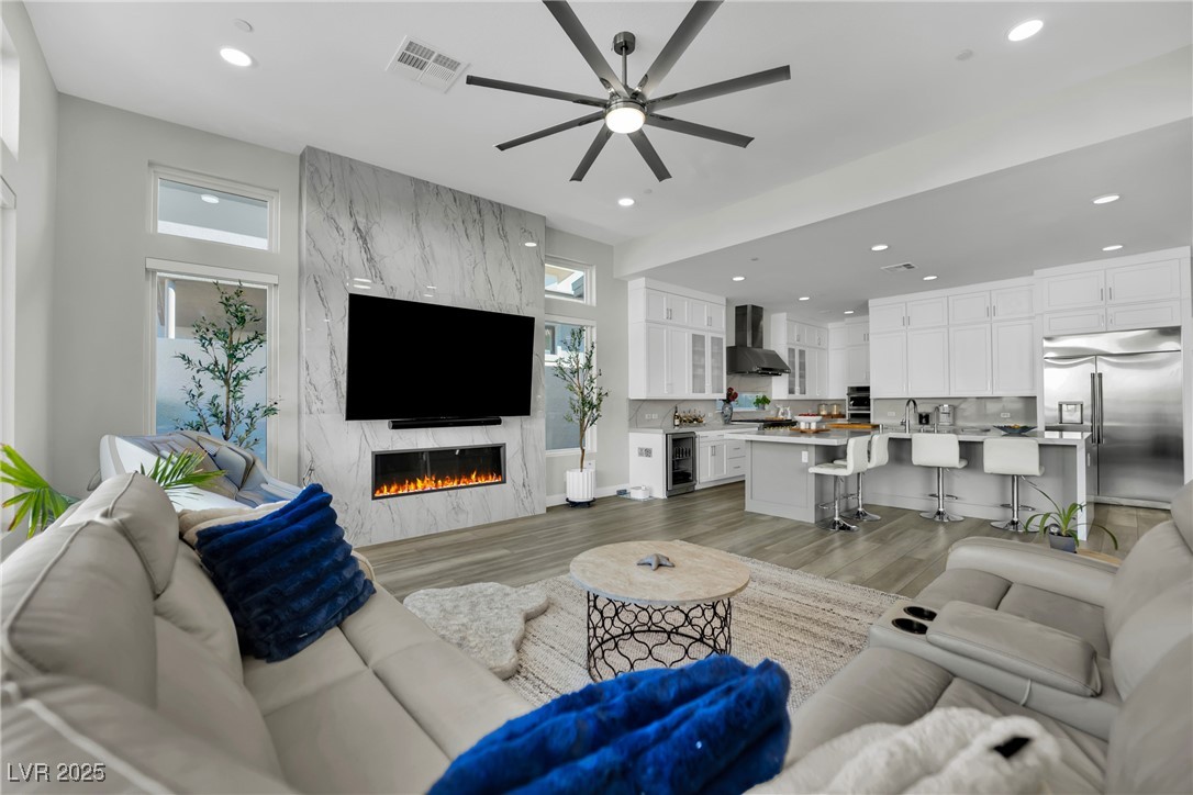 397 Highview Rdg Avenue Las Vegas, NV 89138 - Photo 51 of 97 Living area with ceiling fan, light wood-style floors, wine cooler, a high end fireplace, and recessed lighting