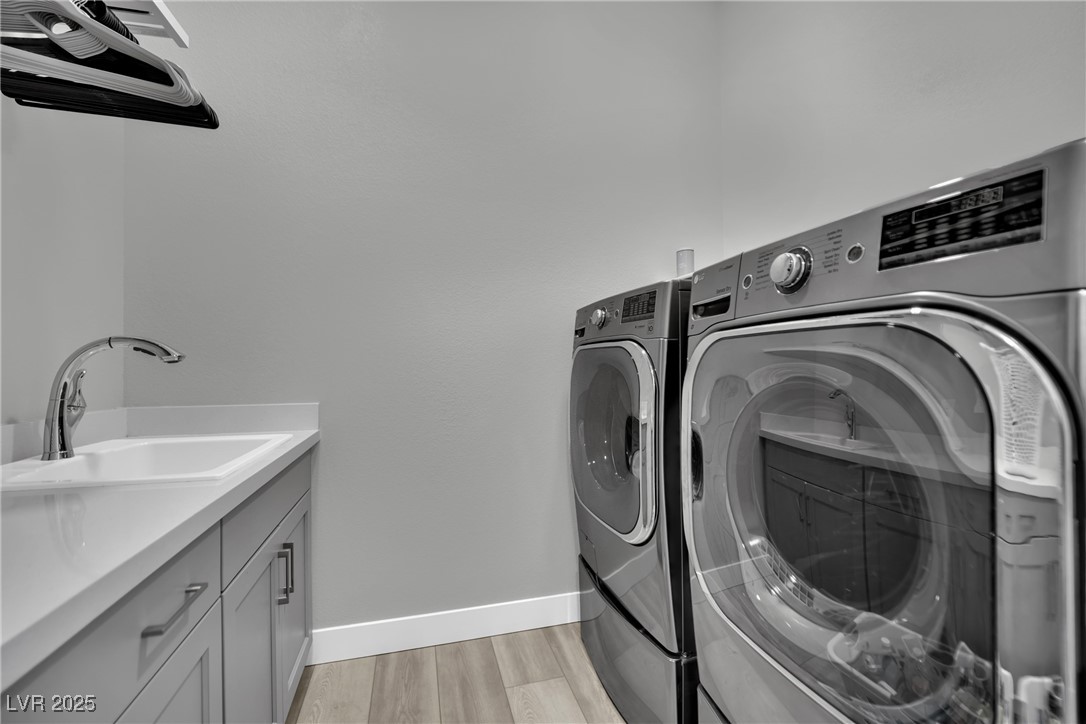 397 Highview Rdg Avenue Las Vegas, NV 89138 - Photo 58 of 97 Laundry area featuring washer and dryer, light wood-style flooring, and cabinet space