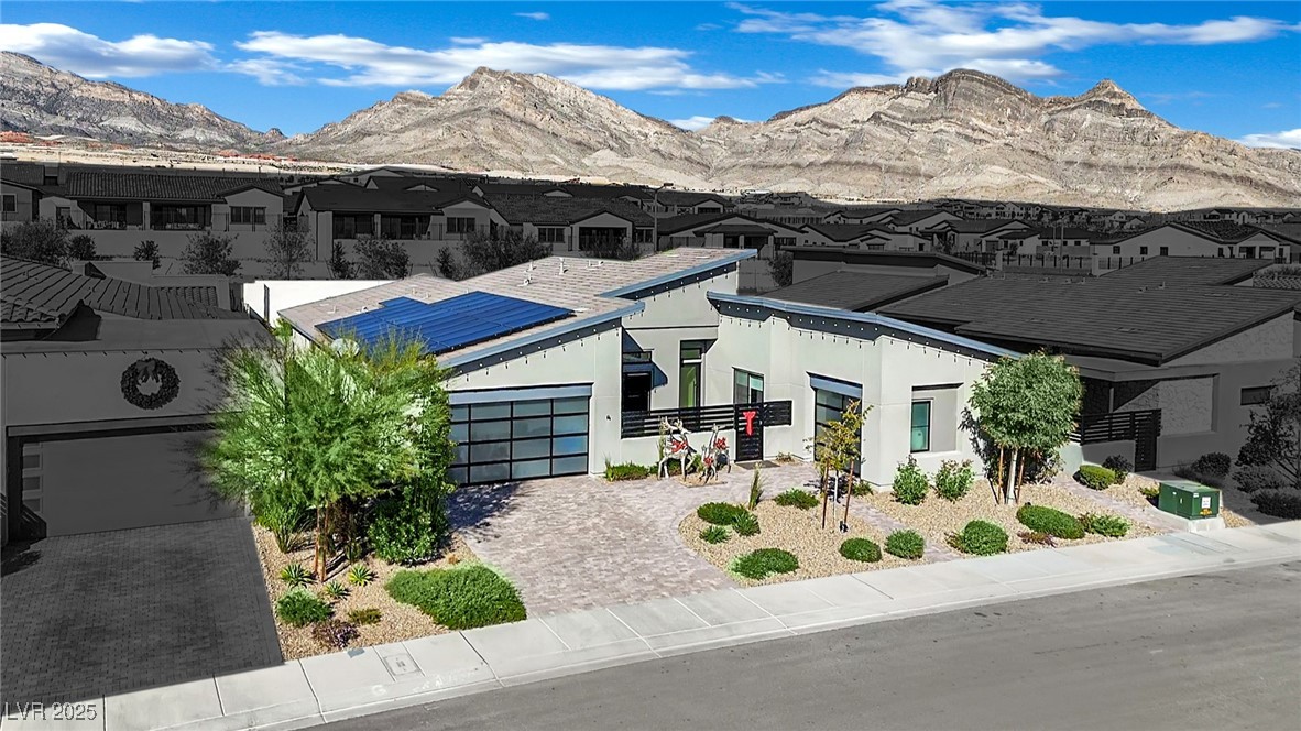 397 Highview Rdg Avenue Las Vegas, NV 89138 - Photo 75 of 97 View of front of property featuring roof mounted solar panels, a residential view, decorative driveway, a mountain view, and an attached garage