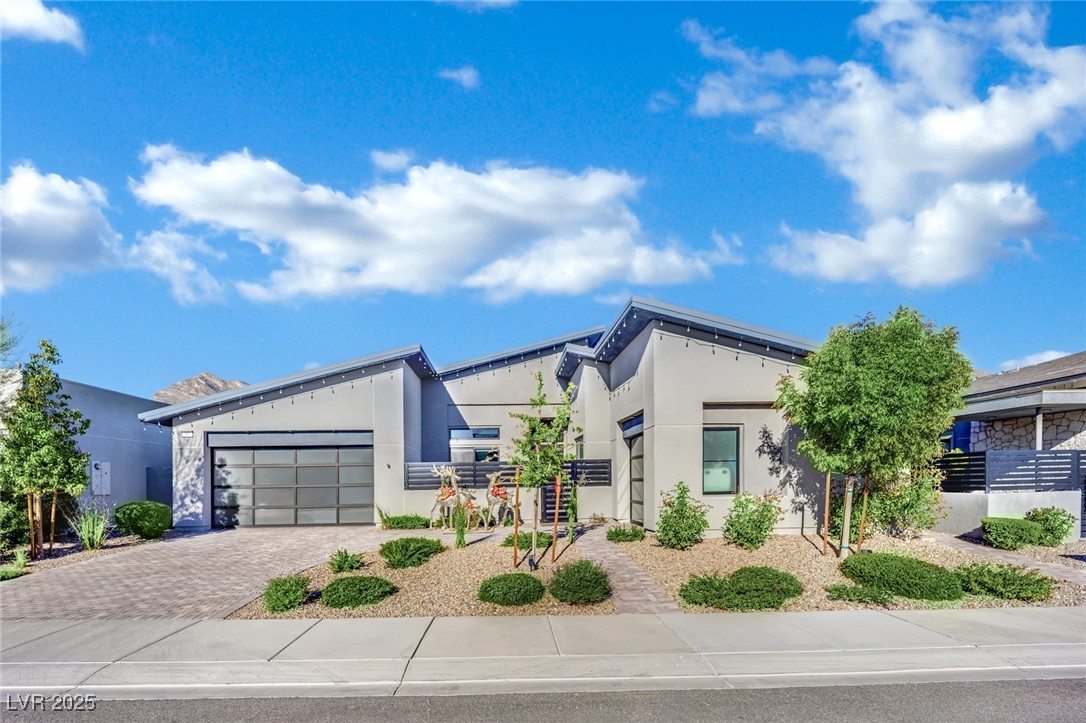 397 Highview Rdg Avenue Las Vegas, NV 89138 - Photo 78 of 97 Contemporary house with stucco siding, decorative driveway, and an attached garage
