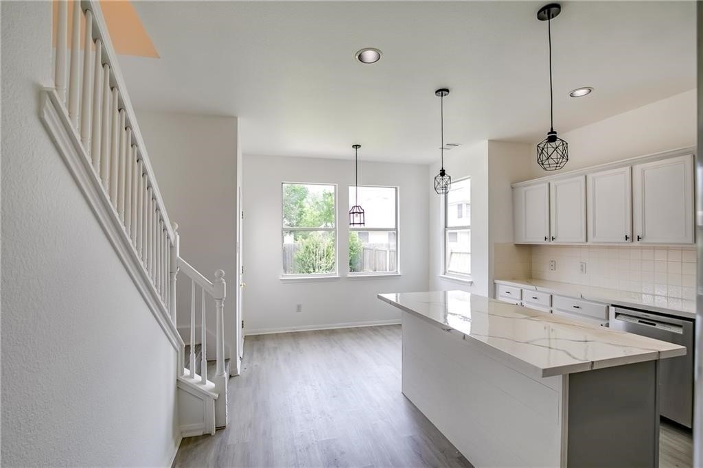 3524 Bratton Ridge Crossing Austin, TX 78728 - Photo 4 of 16 a kitchen with kitchen island a sink a stove a refrigerator and a window