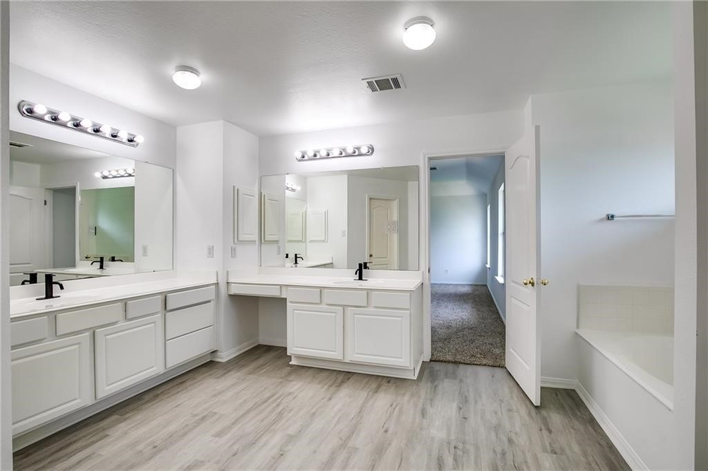 3524 Bratton Ridge Crossing Austin, TX 78728 - Photo 10 of 16 a large bathroom with a double vanity sink a large mirror and a bathtub