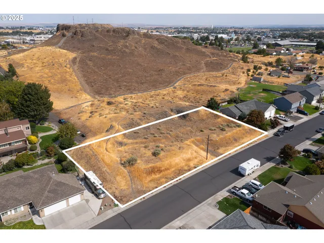 an aerial view of ocean and residential houses with outdoor space