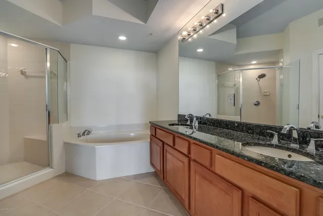 a bathroom with a bathtub double vanity sink and a mirror