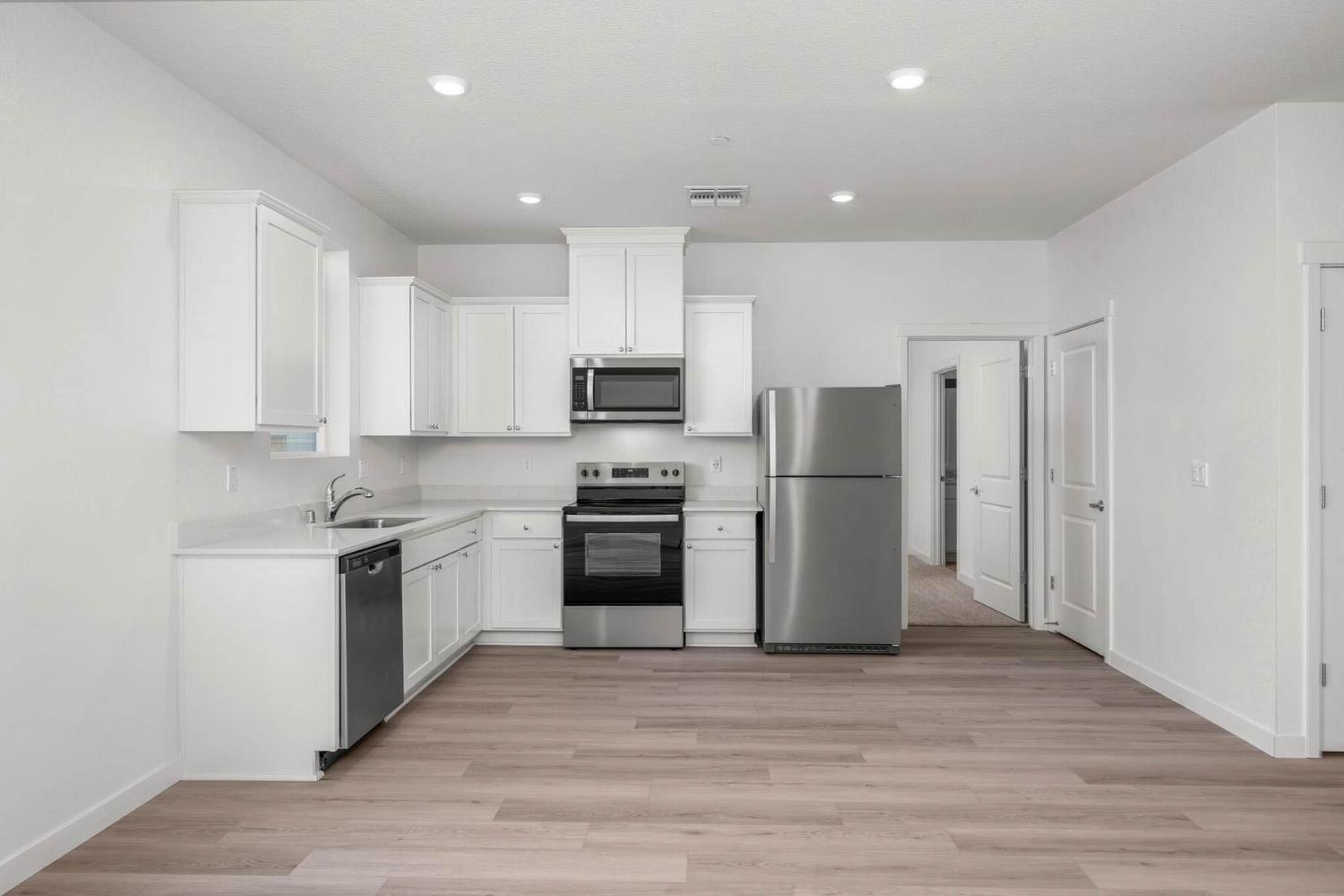 3077 Isley Way Stockton, CA 95212 - Photo 2 of 10 a kitchen with stainless steel appliances granite countertop a stove a refrigerator and a microwave