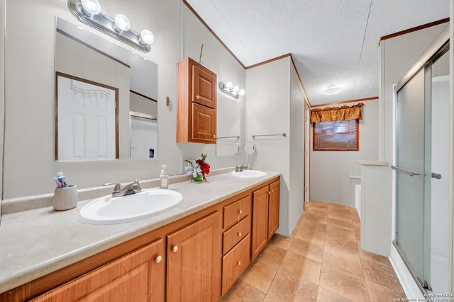 a en suite bathroom with a granite countertop sink a mirror and shower