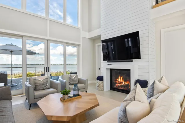 a kitchen with stainless steel appliances kitchen island granite countertop a table chairs and a view of living room