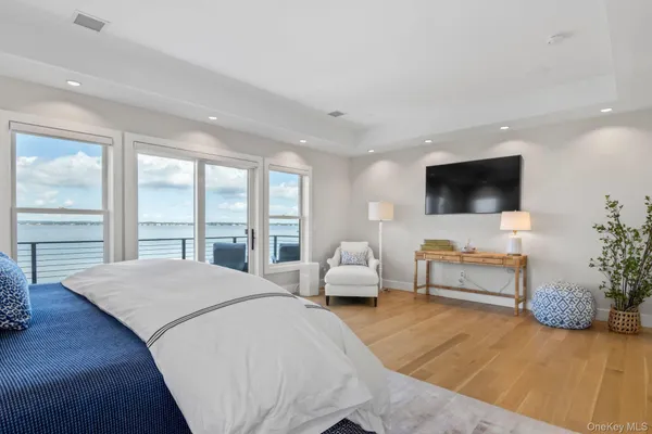 a spacious bedroom with a bed and a flat screen tv
