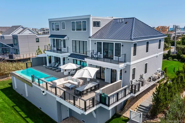 a view of a house with pool and chairs
