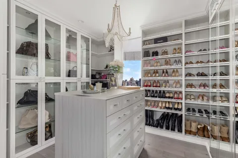 a large bed sitting in a bedroom next to a window and a larger closet