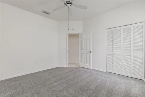 an empty room with a window and a ceiling fan