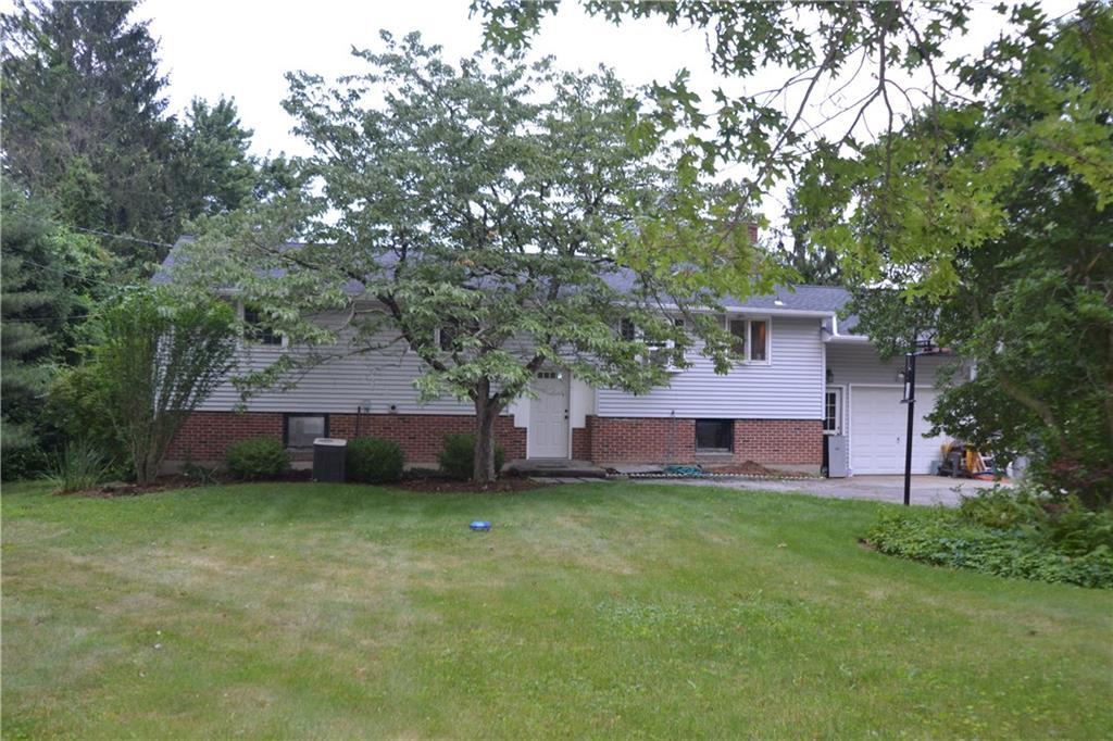 a view of a house with a yard and a tree