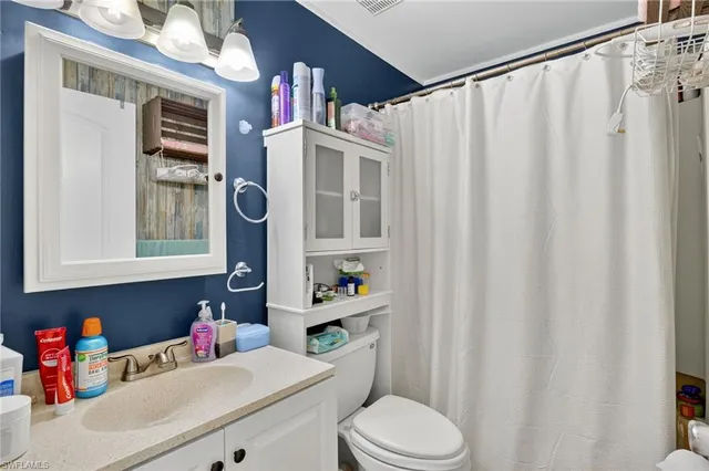 a bathroom with a sink vanity mirror and toilet