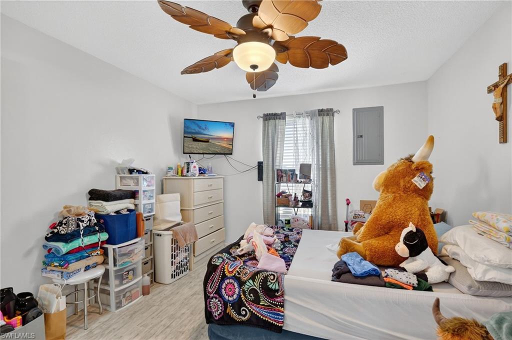 5 Pinewood Boulevard Lehigh Acres, FL 33936 - Photo 19 of 26 a bedroom with a bed and a chandelier