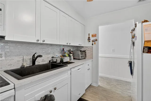 a kitchen with white cabinets and white appliances