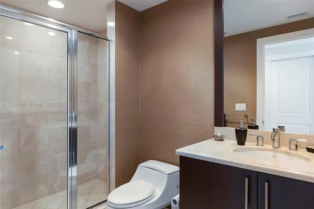 a bathroom with a sink a toilet a shower and a mirror