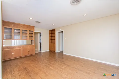 an empty room with wooden cabinet and door