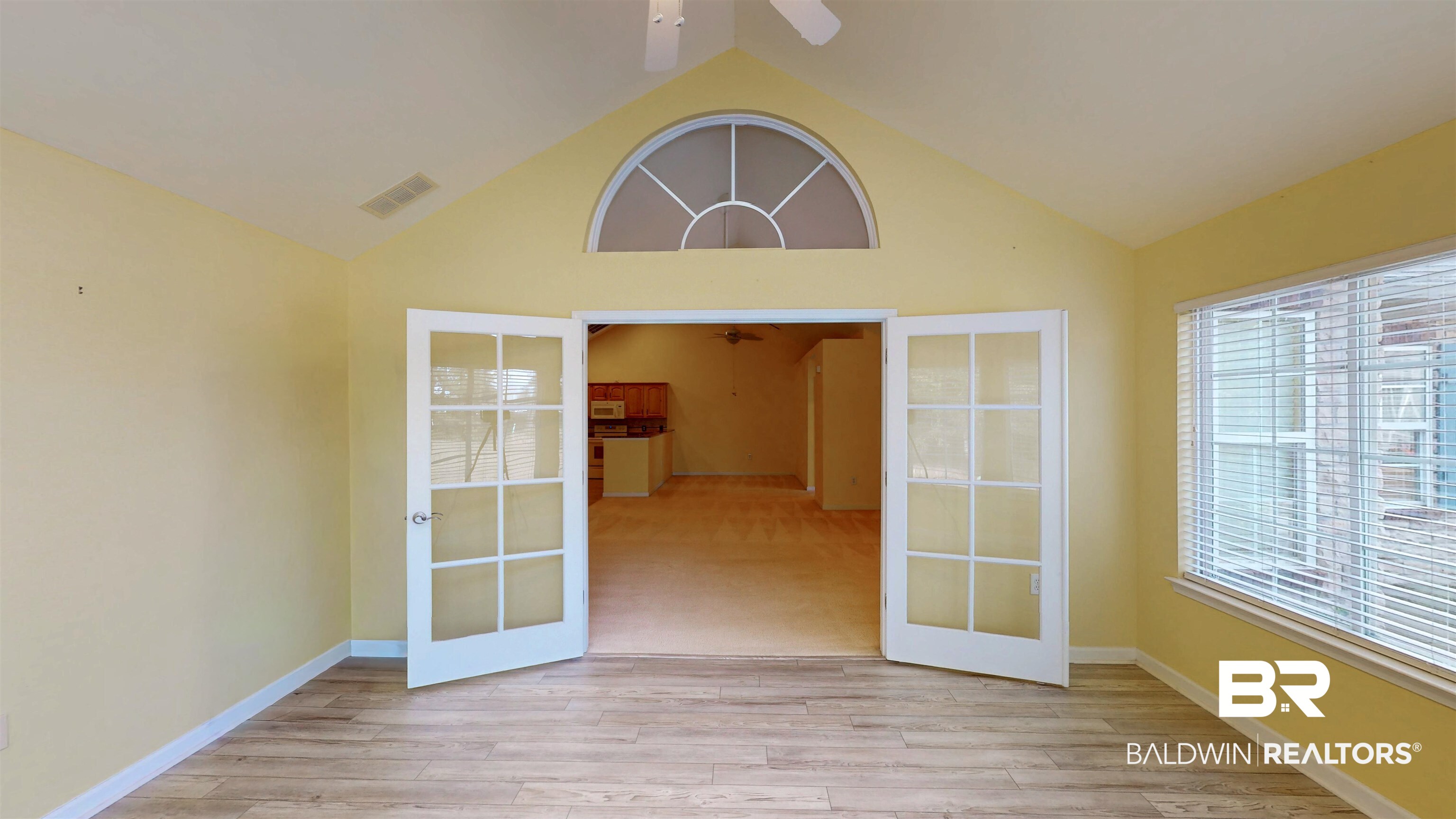 303 Wyld Palms Drive, Unit 303 Foley, AL 36535 - Photo 9 of 36 Unfurnished room with french doors, light wood finished floors, a ceiling fan, and high vaulted ceiling