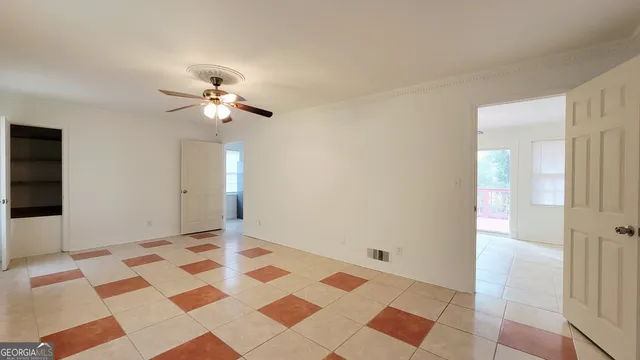a view of a bedroom with a chandelier fan and windows