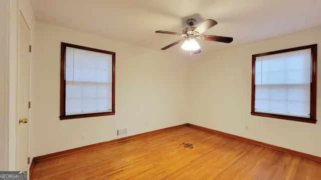 a view of empty room with wooden floor