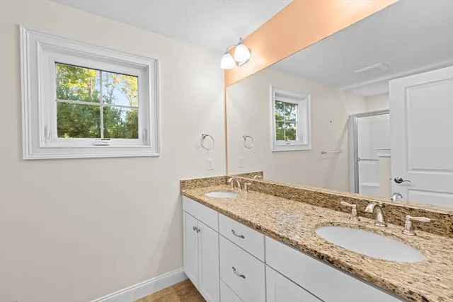 a bathroom with a granite countertop sink and a mirror