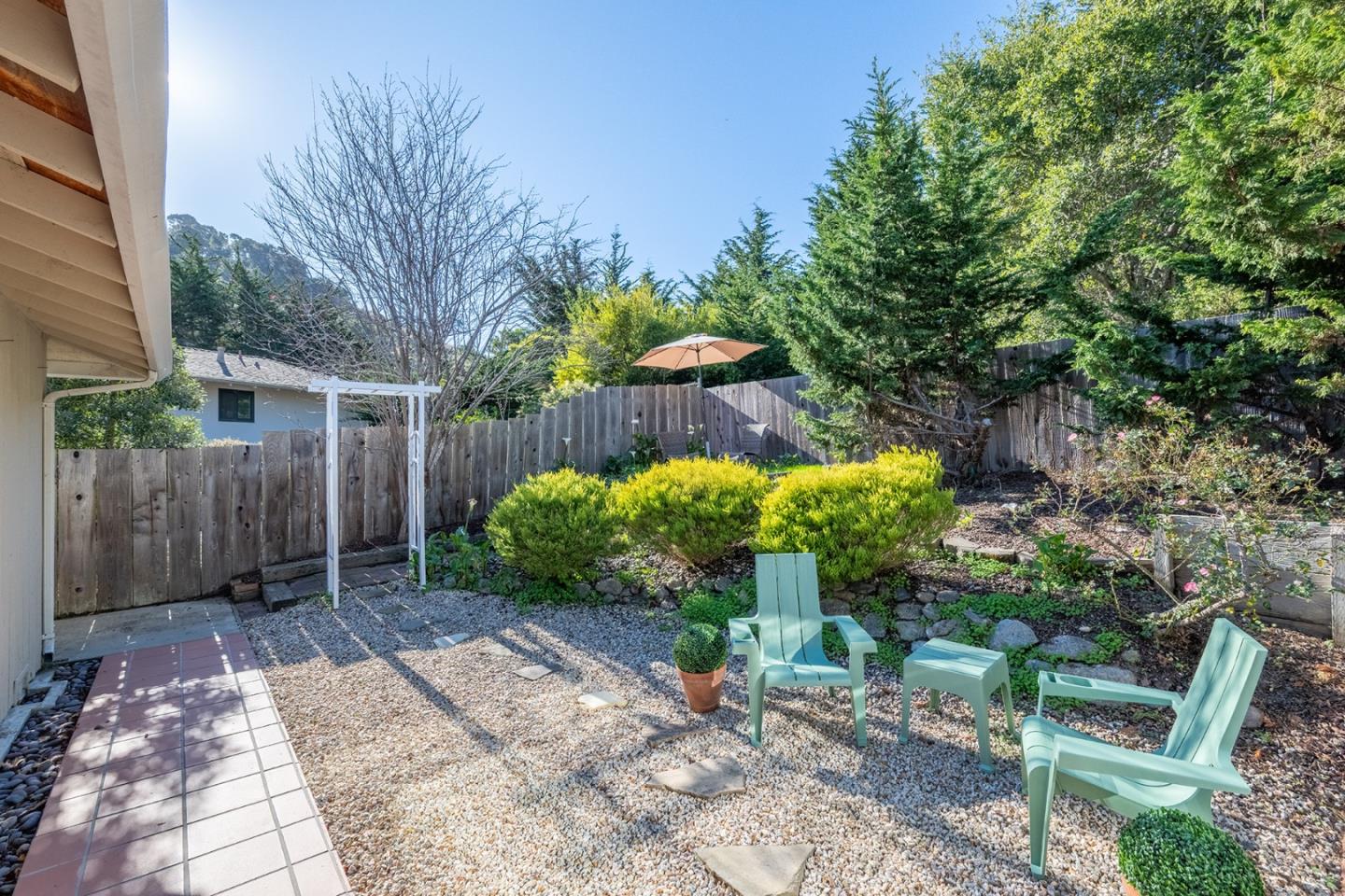 3050 Ribera Road Carmel, CA 93923 - Photo 24 of 27 a backyard with table and chairs and potted plants
