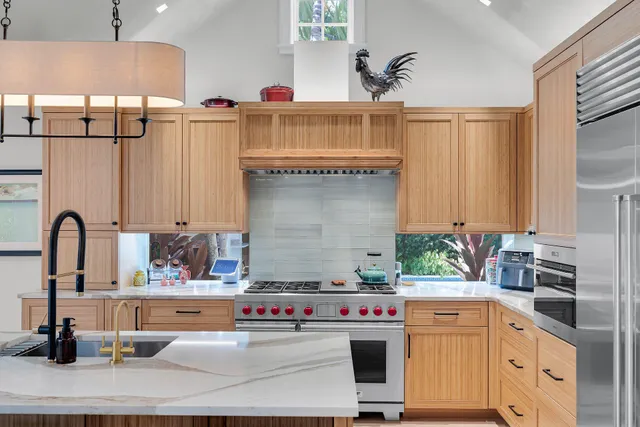 a kitchen with stainless steel appliances granite countertop a sink a stove and a wooden floors