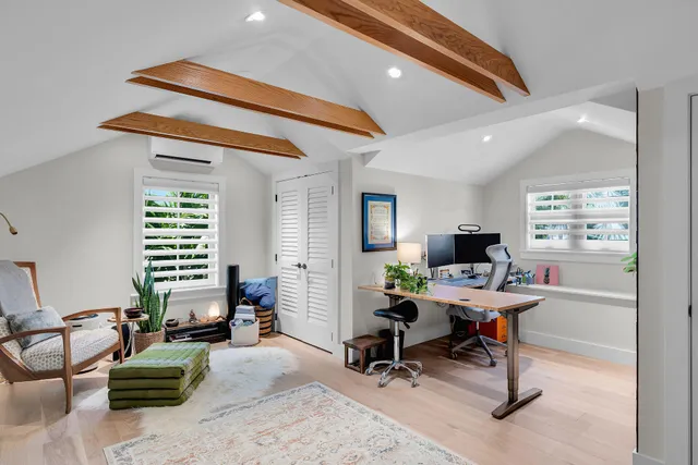 a bedroom with a bed and a chair with the wooden floor
