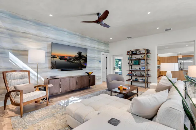 a dining hall with stainless steel appliances kitchen island granite countertop a table chairs and a refrigerator