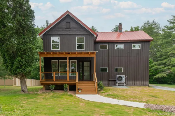 a view of a house with a yard balcony and a tree