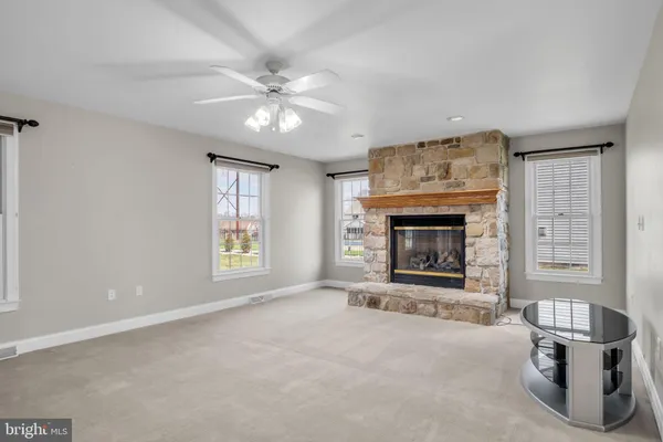 a view of an empty room with window and fireplace