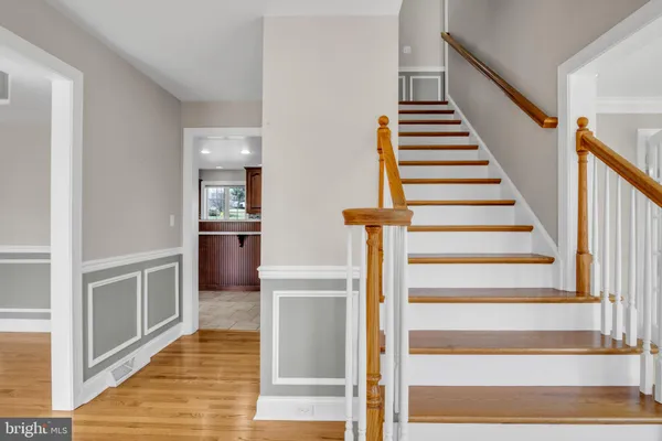 a view of a hallway with wooden floor and staircase
