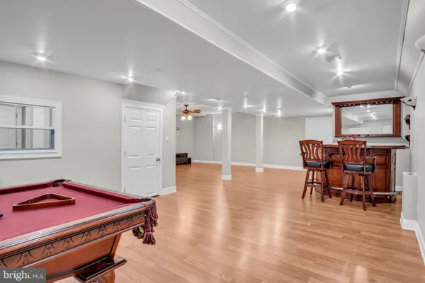 a view of an empty room with kitchen and chandelier fan