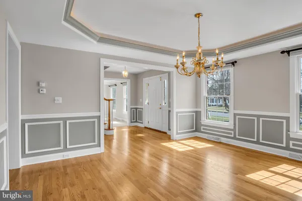 a view of a livingroom with a chandelier fan and kitchen view