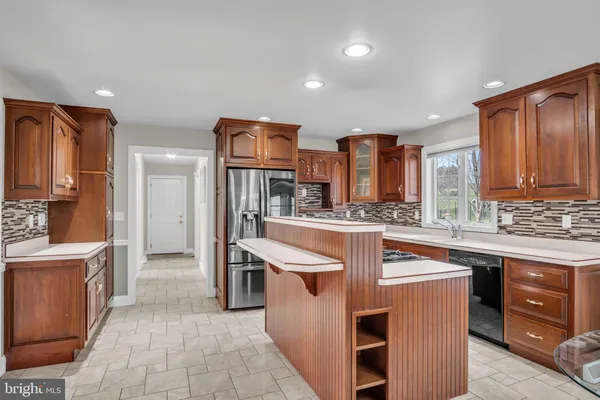 a kitchen with stainless steel appliances granite countertop a stove a sink and a refrigerator