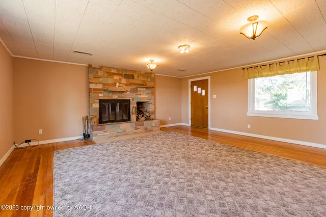 a view of a livingroom with a fireplace and window