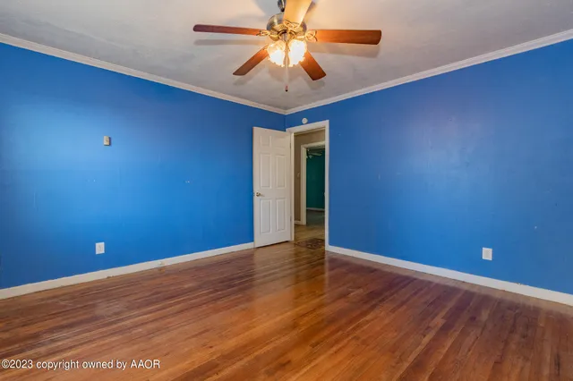 a view of a livingroom with a chandelier fan and wooden floor