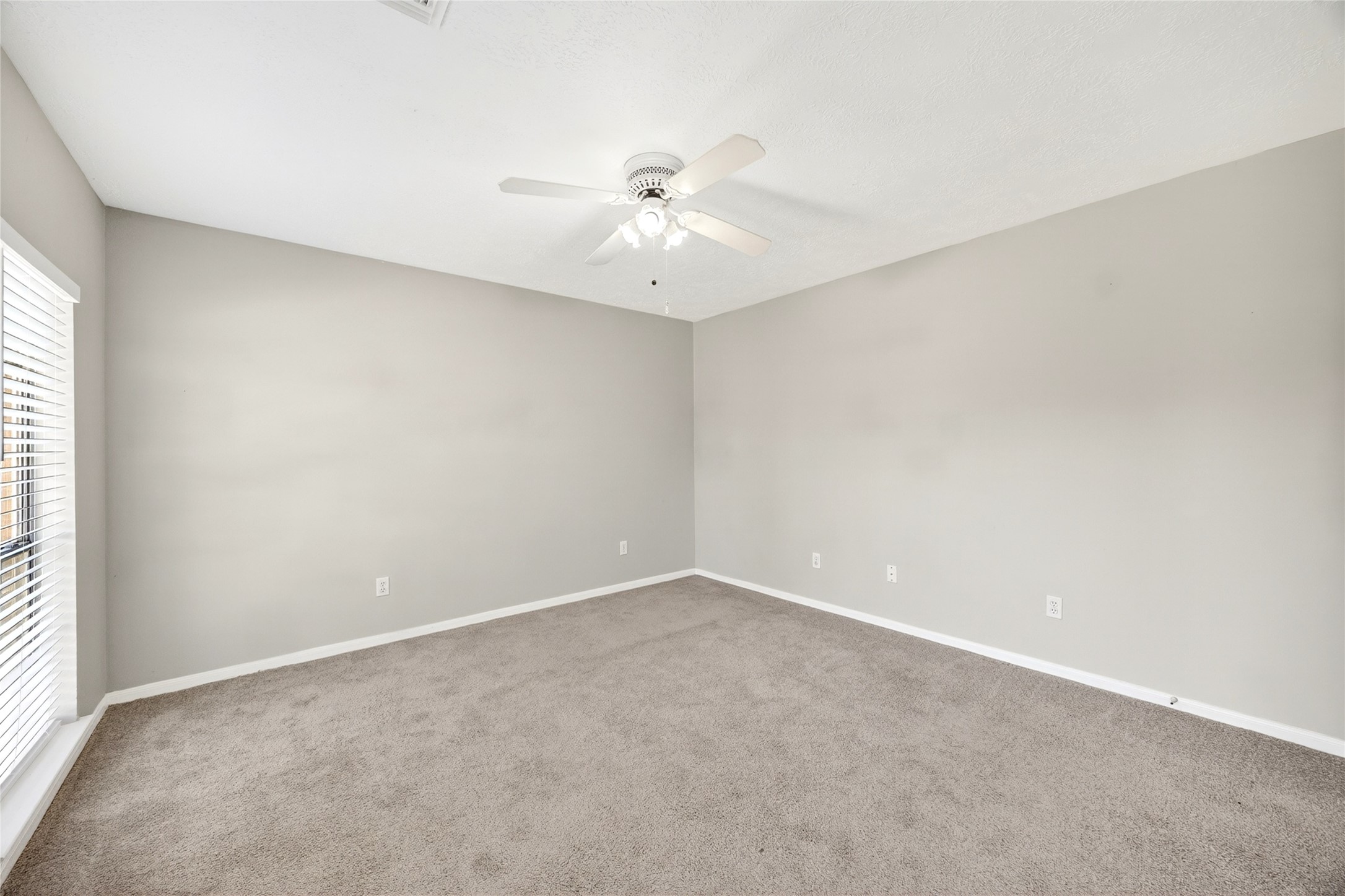 10615 Vandercroft Court Houston, TX 77070 - Photo 34 of 47 an empty room with a window and a ceiling fan
