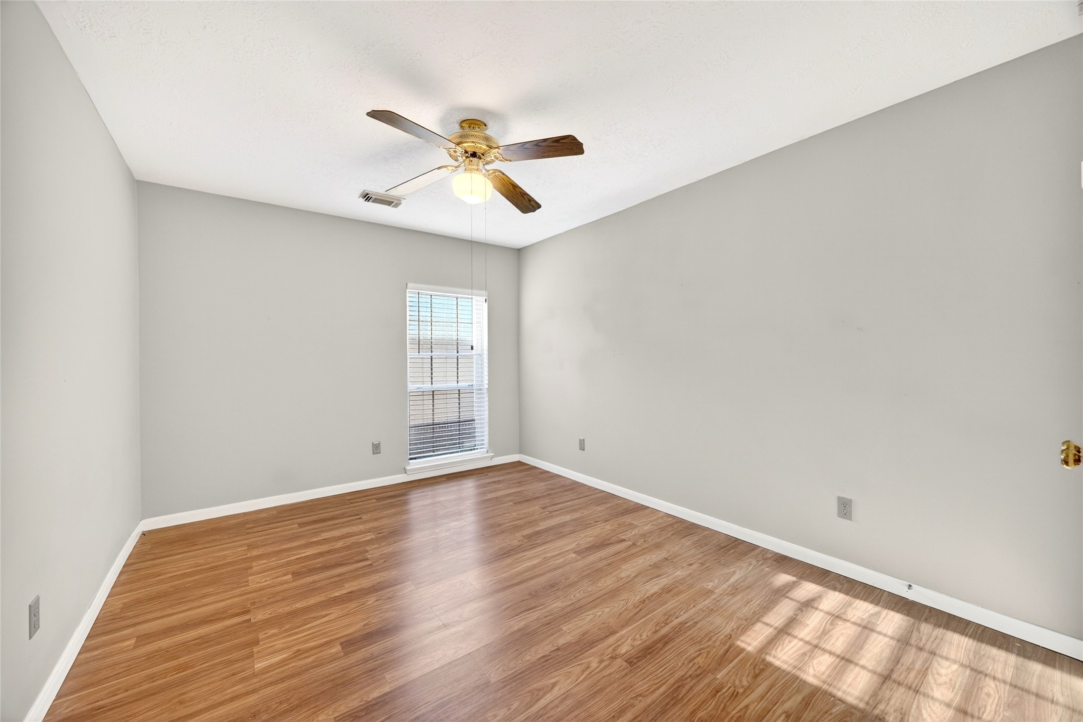 10615 Vandercroft Court Houston, TX 77070 - Photo 36 of 47 an empty room with wooden floor fan and windows