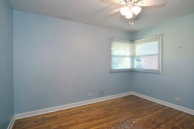 a view of a room with wooden floor and fan
