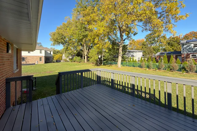 a view of a balcony with wooden floor and fence