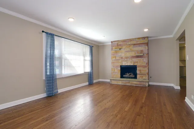 an empty room with wooden floor and a fireplace