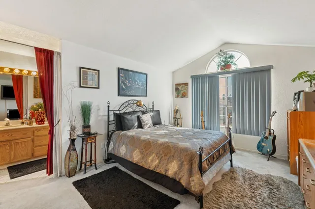 a bedroom with a bed and a mirror on the dresser