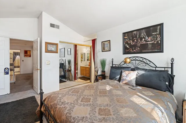 a bedroom with a bed and a large mirror